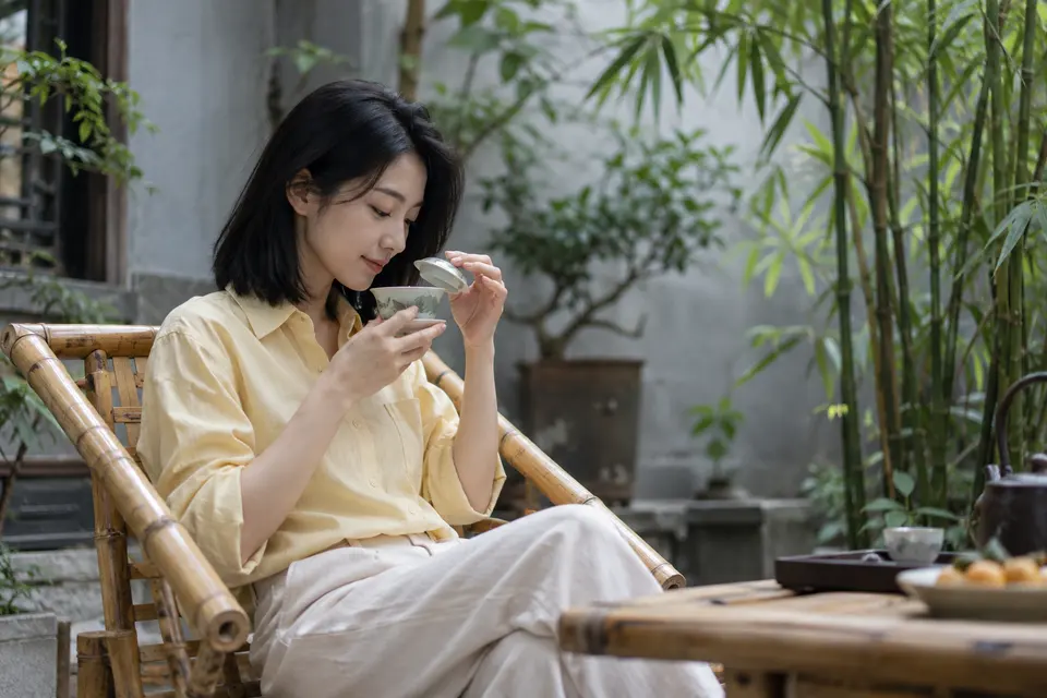 竹影院落中，盖碗茶置于茶桌，茶友闻香